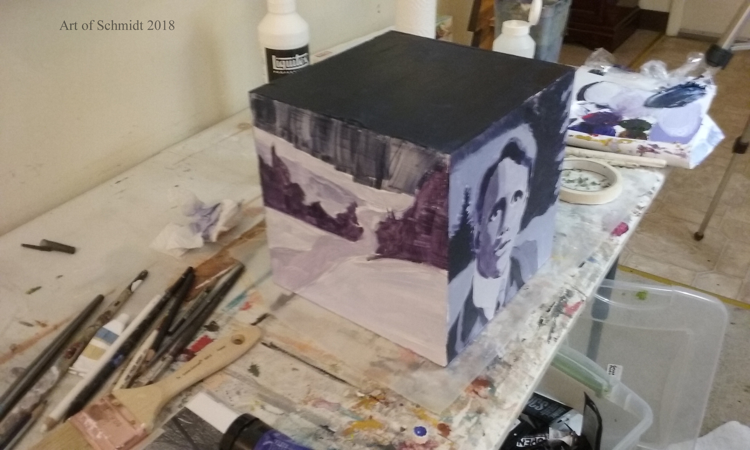 Three dimensional cube with portrait and landscape painting.